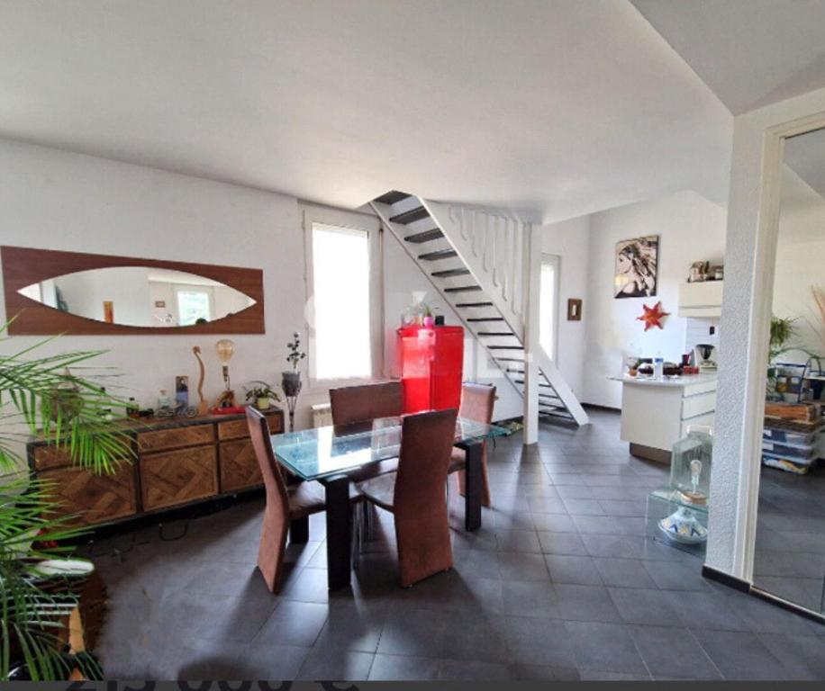 a living room with a table and a staircase at Appartement spacieux et confortable in Valence