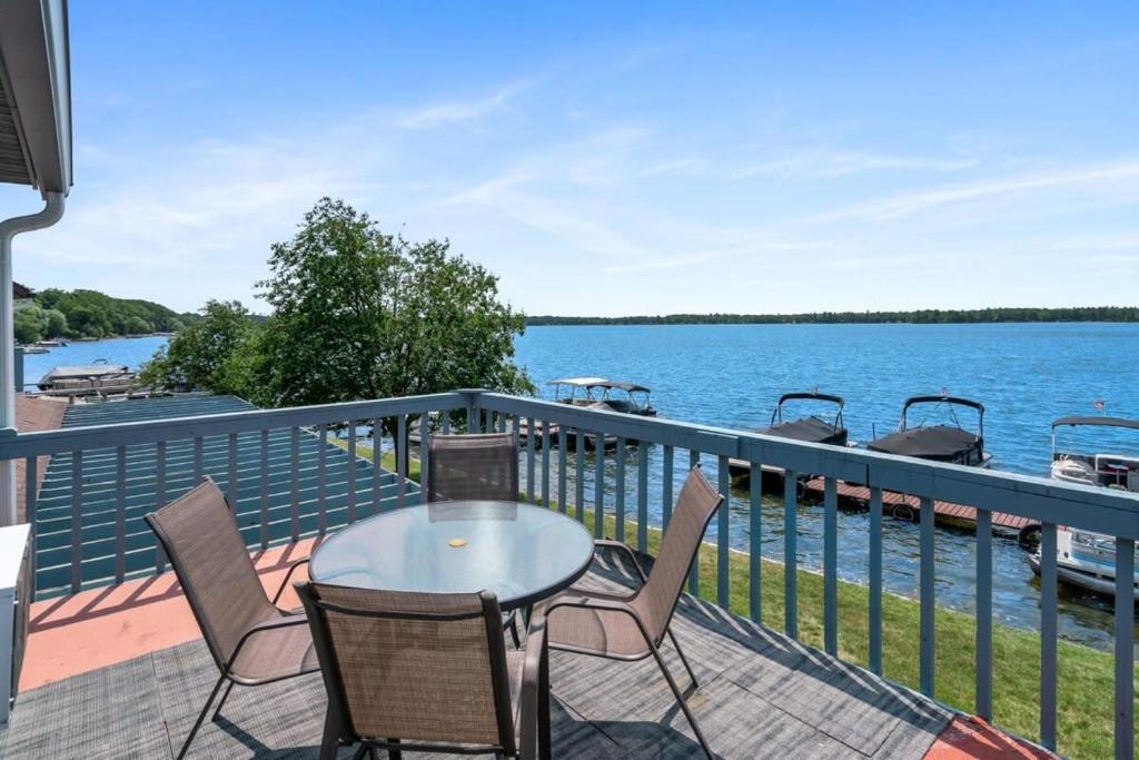 a balcony with a table and chairs and a view of the water at Fife Lake Lodge Multi-level Suite with Lake Views in Fife Lake