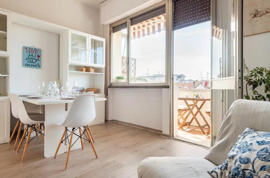 een woonkamer met een tafel en stoelen en een eetkamer bij [Seaside Apt] Private Parking and near the beach in Viareggio