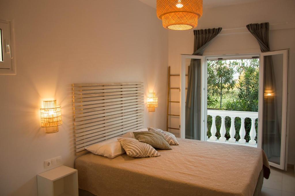 a bedroom with a bed with two pillows and a window at Aristidis Apartments in Agios Georgios