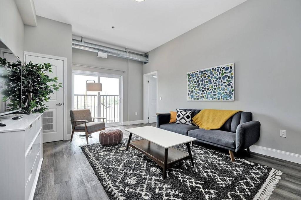 a living room with a couch and a table at High-end condo downtown Kingston near RMC Queens in Kingston