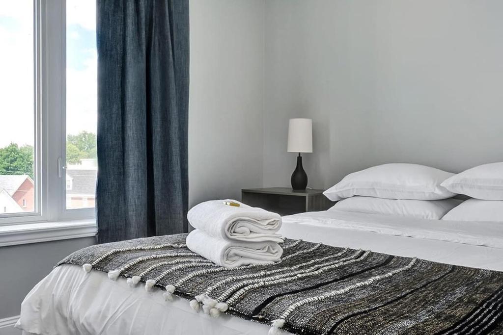 Postel nebo postele na pokoji v ubytování High-end condo downtown Kingston near RMC Queens