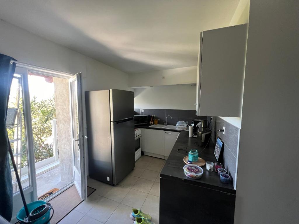 una cucina con frigorifero in acciaio inossidabile e finestra di Couderc a Viviers