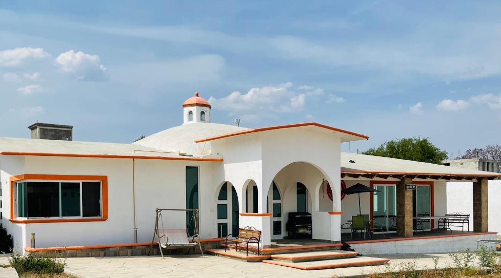 een wit huis met een veranda en een dak bij Quinta Tequis San José in La Laja