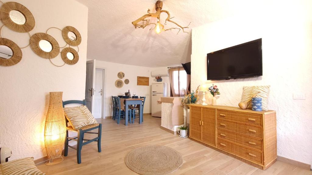 Una sala de estar con un televisor de pantalla plana en una pared. en Villa Sa Mama, en San Teodoro