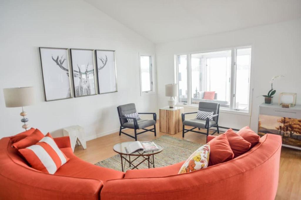 een woonkamer met een rode bank en stoelen bij The Verne: Beautiful Waterfront Escape by Picton in Picton