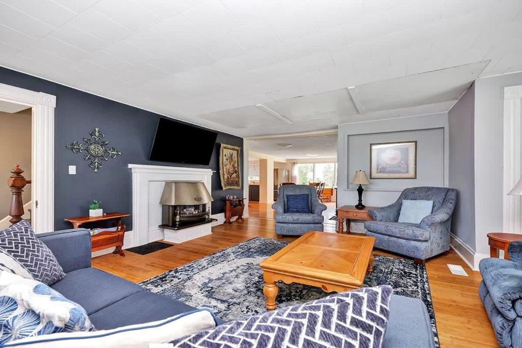ein Wohnzimmer mit einem Sofa, Stühlen und einem TV in der Unterkunft The Highway House - PEC Waterview Getaway in Wellington