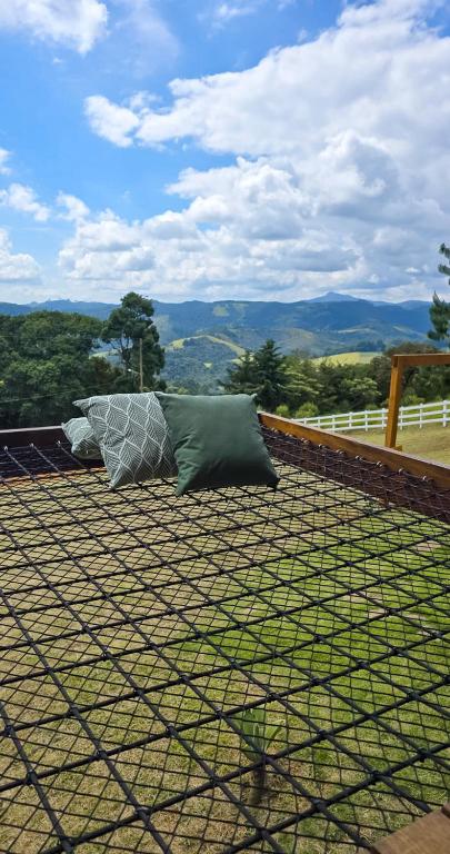 two pillows are sitting on top of a roof at POUSADA QUINTAL DAS OLIVEIRAS in Monte Verde