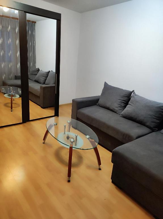 - un salon avec un canapé et une table en verre dans l'établissement La Adelina, à Focşani