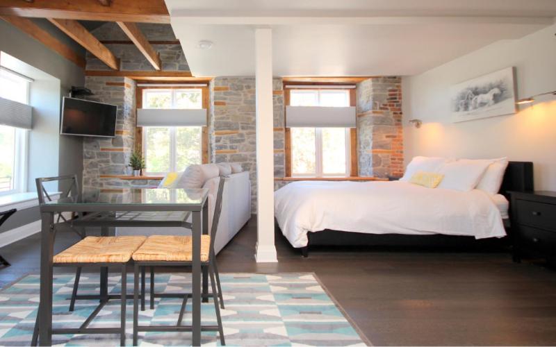 1 dormitorio con 1 cama y 1 mesa en una habitación en Kemptville Suites en Kemptville