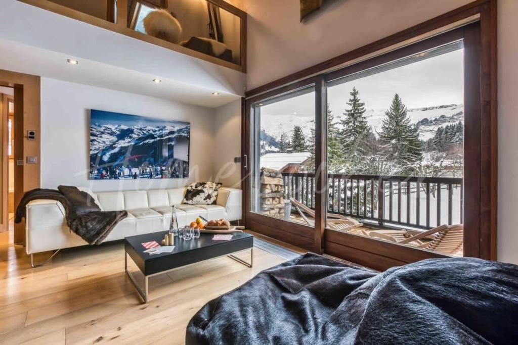 a living room with a couch and a large window at Yupik in Megève