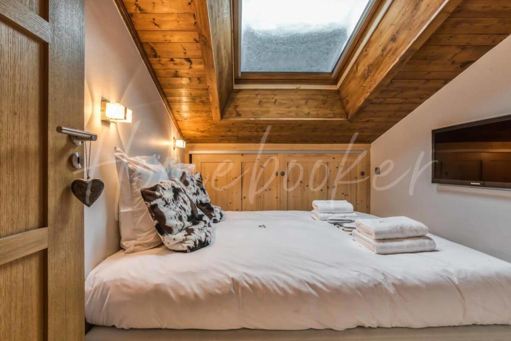 a bedroom with a large bed with a window at Yupik in Megève
