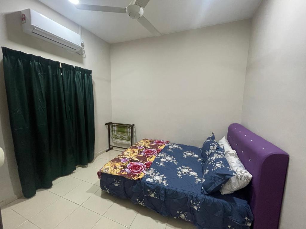 a bedroom with a purple bed and a green curtain at Irdina Homestay Beserah, Kuantan in Kuantan
