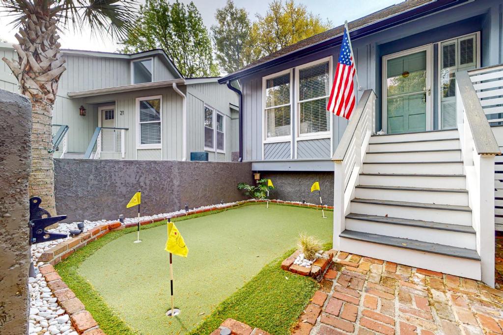 a house with a miniature golf course in the yard at The Palm Frond Stay in Isle of Palms