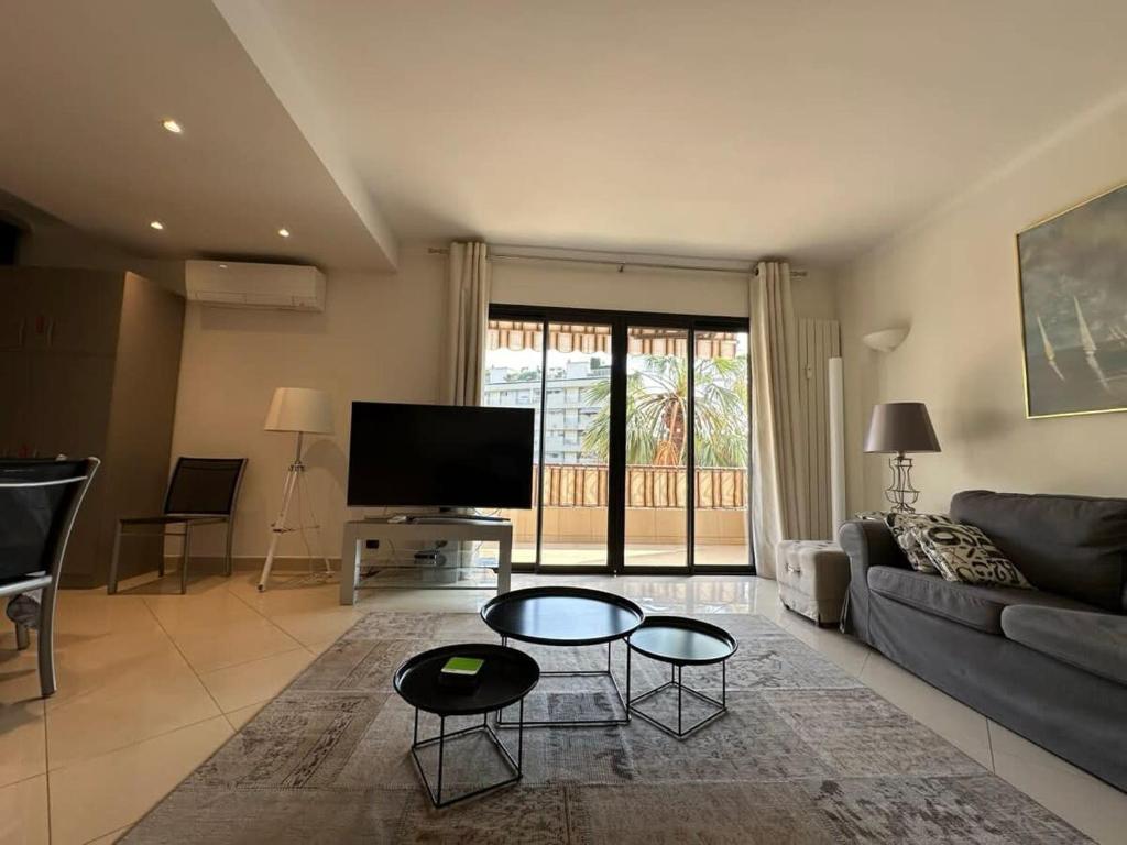 un salon avec un canapé et une télévision dans l'établissement A003-Magnifique appartement proche du centre de Cannes, à Cannes