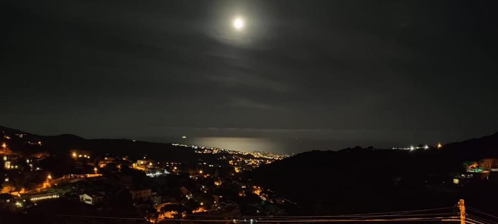 a view of a city at night with the moon at Habitación en Alella in Alella
