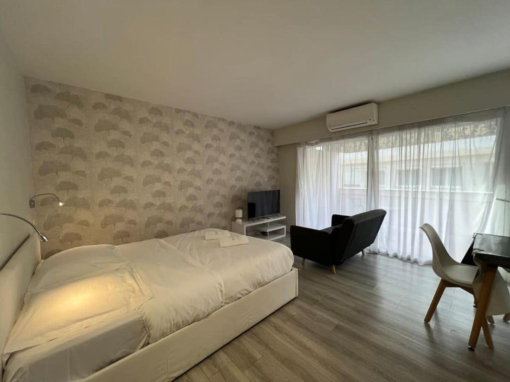 een slaapkamer met een bed, een bureau en een televisie bij Beau studio Carré D'Or & Proche de la Mer Cannes in Cannes