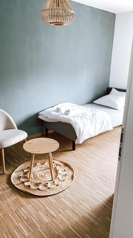 a bedroom with a bed and a table and a chair at DoreyHome P2 - modernes zentrales Apartment -2-4 Personen - Parkplatz in Passau