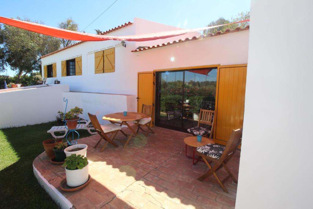 a patio with a table and chairs in front of a house at Casa Mar in Burgau