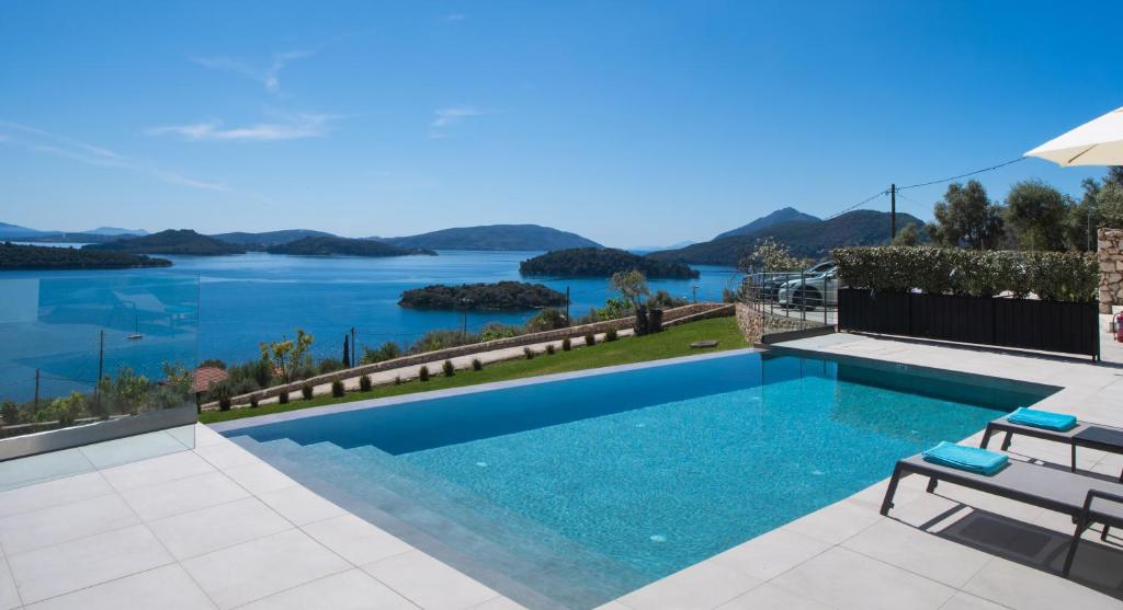 a swimming pool with a view of the water at Apaggio Villas in Nydri