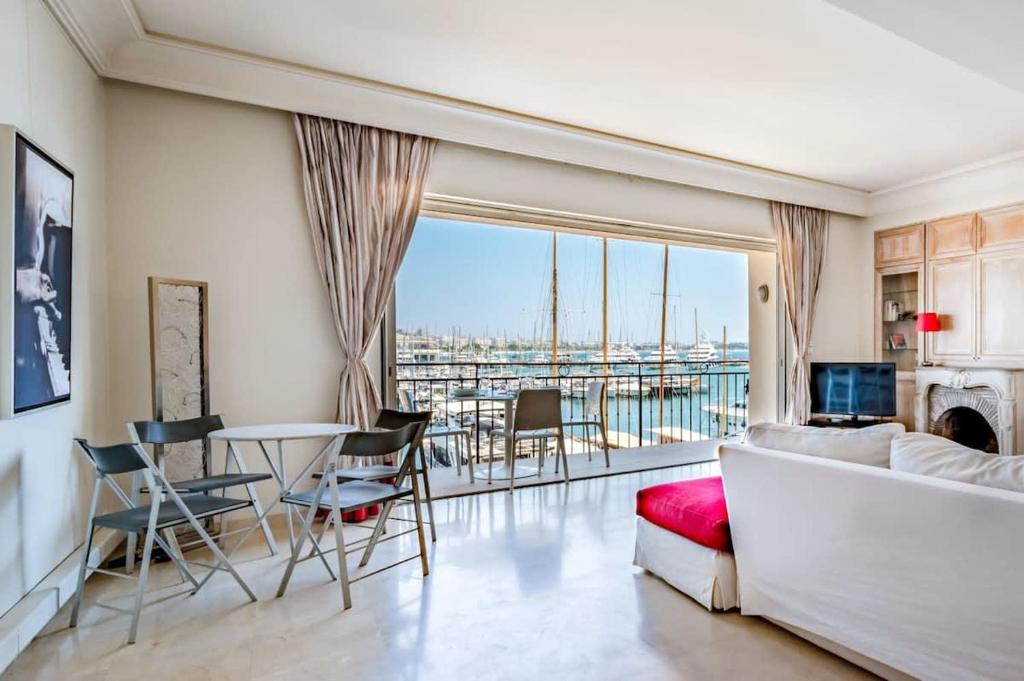 un salon avec un canapé et une table avec des chaises dans l'établissement C096-Apt overlooking the Old Port the view is magical, à Cannes