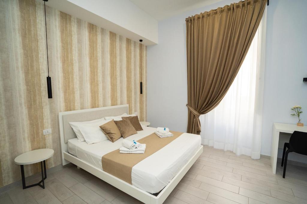 a bedroom with a bed and a desk and a window at Mida's Boutique Rooms in Naples