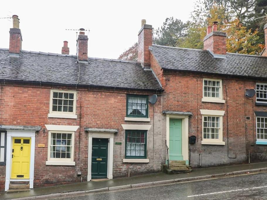a row of brick houses with colorful doors at Rosie Cottage in Ashbourne