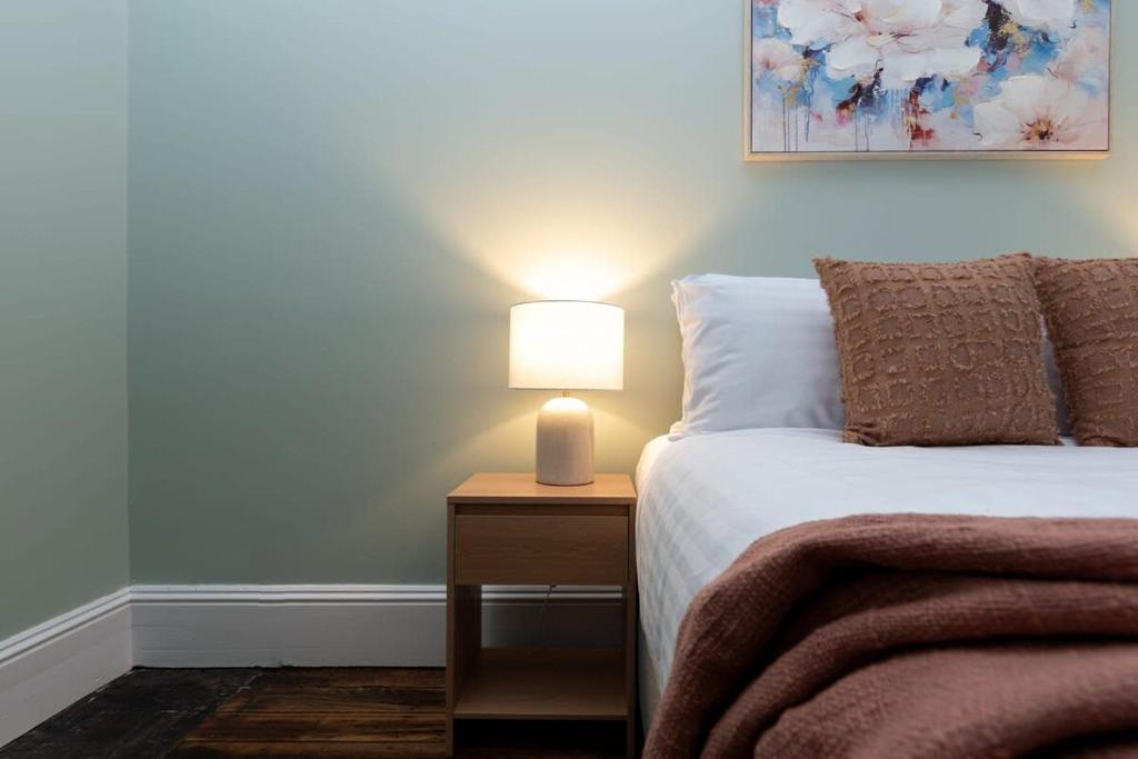 een slaapkamer met een bed met een lamp op een nachtkastje bij Classic Cottage: Near CBD Hospital & Parking in Kings Park