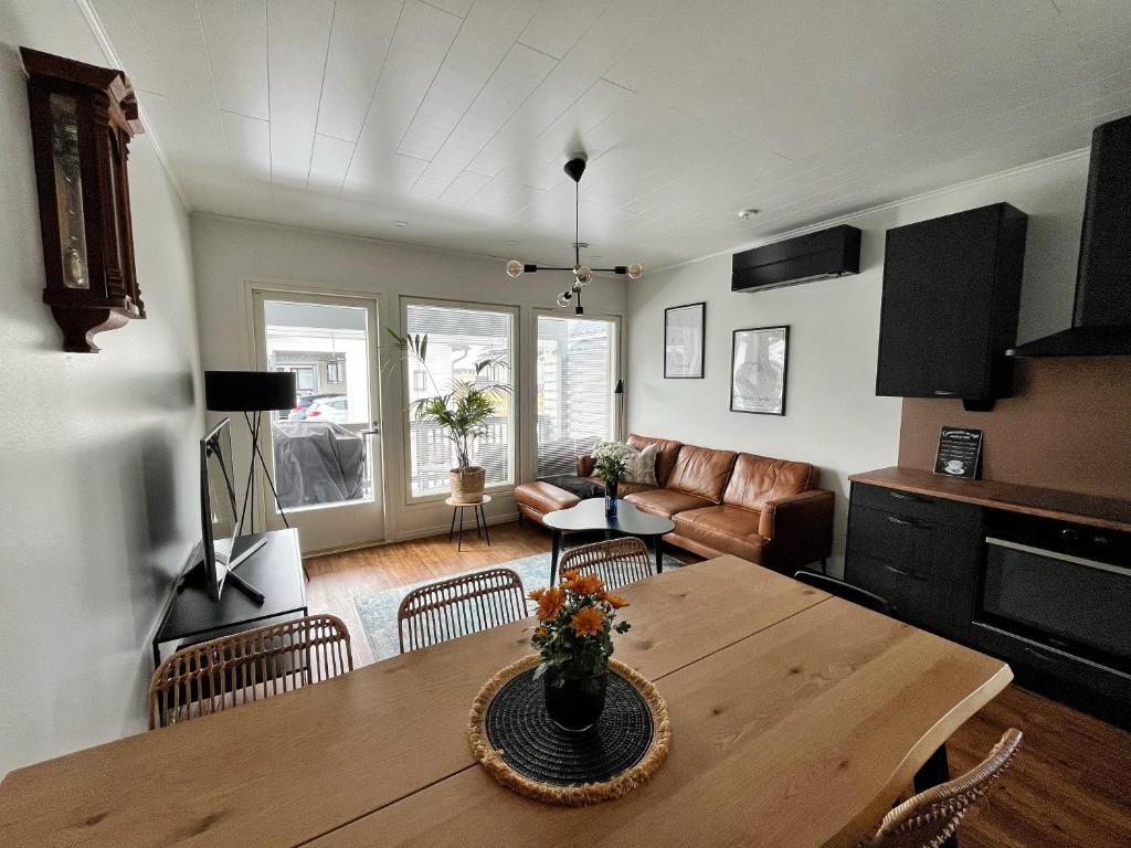 uma sala de estar com uma mesa e um sofá em Modern & Stylish 2BR Apartment with Sauna, Terrace and Free Private Parking em Lahti