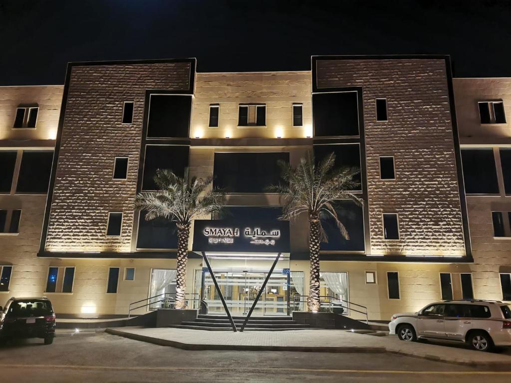 a building with palm trees in front of it at Smayah Residence in Riyadh