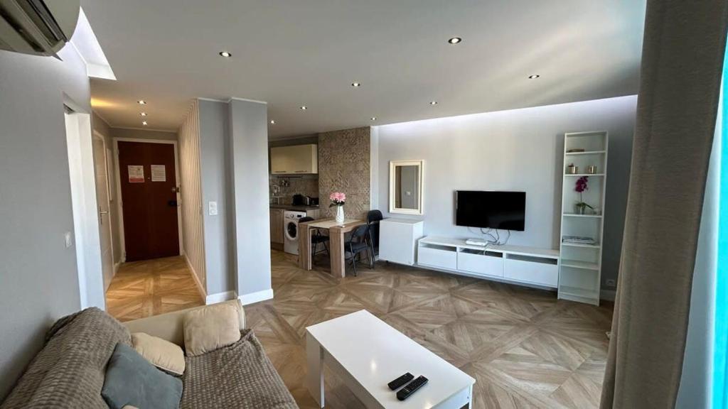 un salon avec un canapé et une télévision dans l'établissement B018-Bright apartment with balcony - Cannes Croisette, à Cannes
