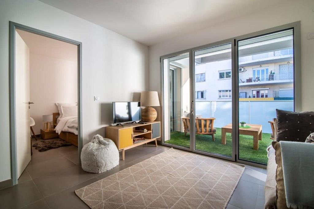 un salon avec une télévision et une grande fenêtre dans l'établissement A059-New apt with south facing - Terrace-Near the beach, à Antibes
