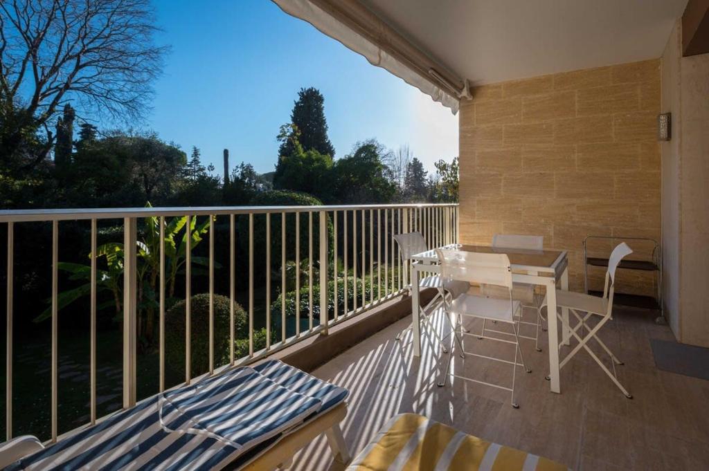un balcon avec un bureau blanc et des chaises dessus dans l'établissement A081-Cannes Appartement avec terrasse au calme, à Cannes
