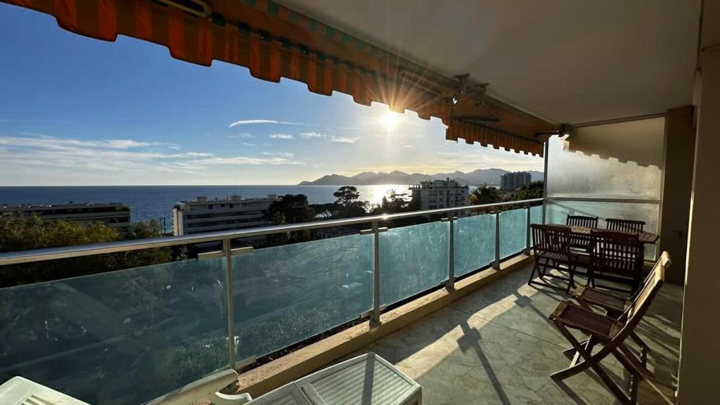 un balcon avec deux chaises et une vue sur l'océan dans l'établissement A069-Apt in residence with pool and sea view - Cannes, à Cannes