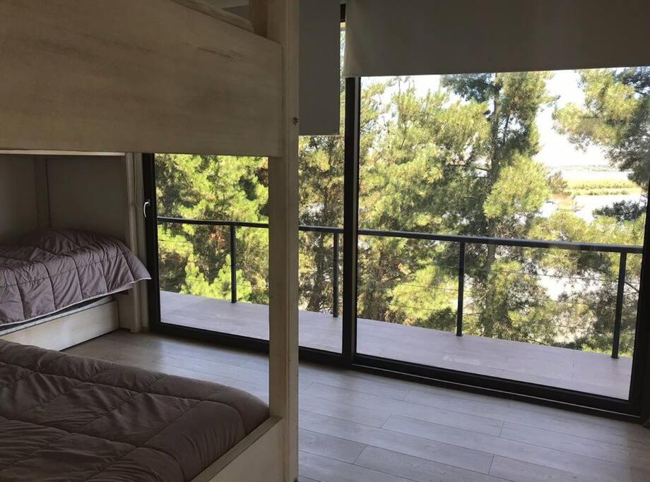a bedroom with a bed and a large window at Casa Bosque Vista Hermosa al Lago Rapel in Las Cabras
