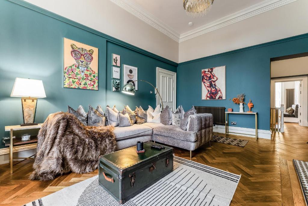 a living room with blue walls and a couch at Luxurious Park District Duplex Apartment in Glasgow