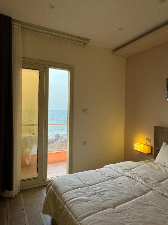een slaapkamer met een bed en uitzicht op de oceaan bij Alex Inn in Alexandrië