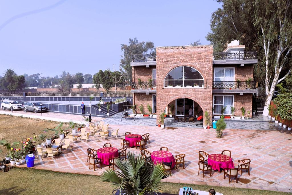 a building with pink tables and chairs on a patio at Ayaansh Resort- Westin Sohna Complex in Sohna