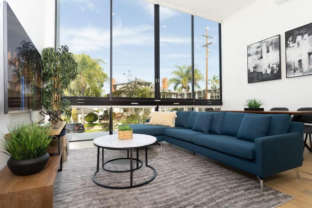 a living room with a blue couch and a table at Bright and Trendy 2-story Bankers Hill Condo in San Diego