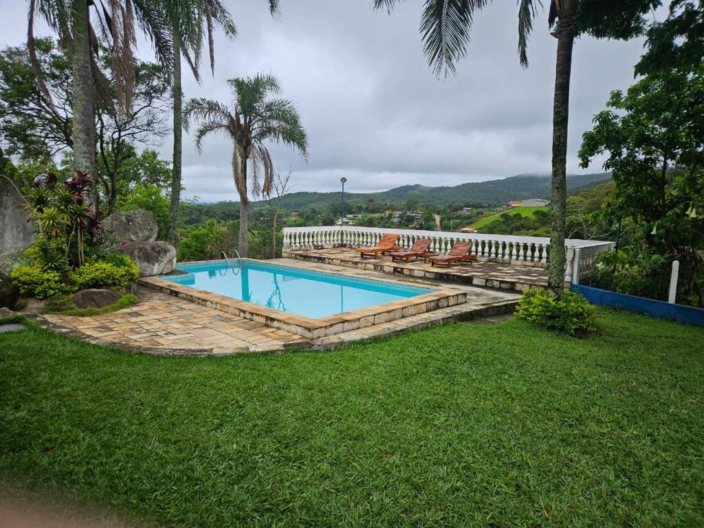- une piscine dans une cour avec un banc dans l'établissement Sítio Sta Filomena, à Vargem Grande Paulista
