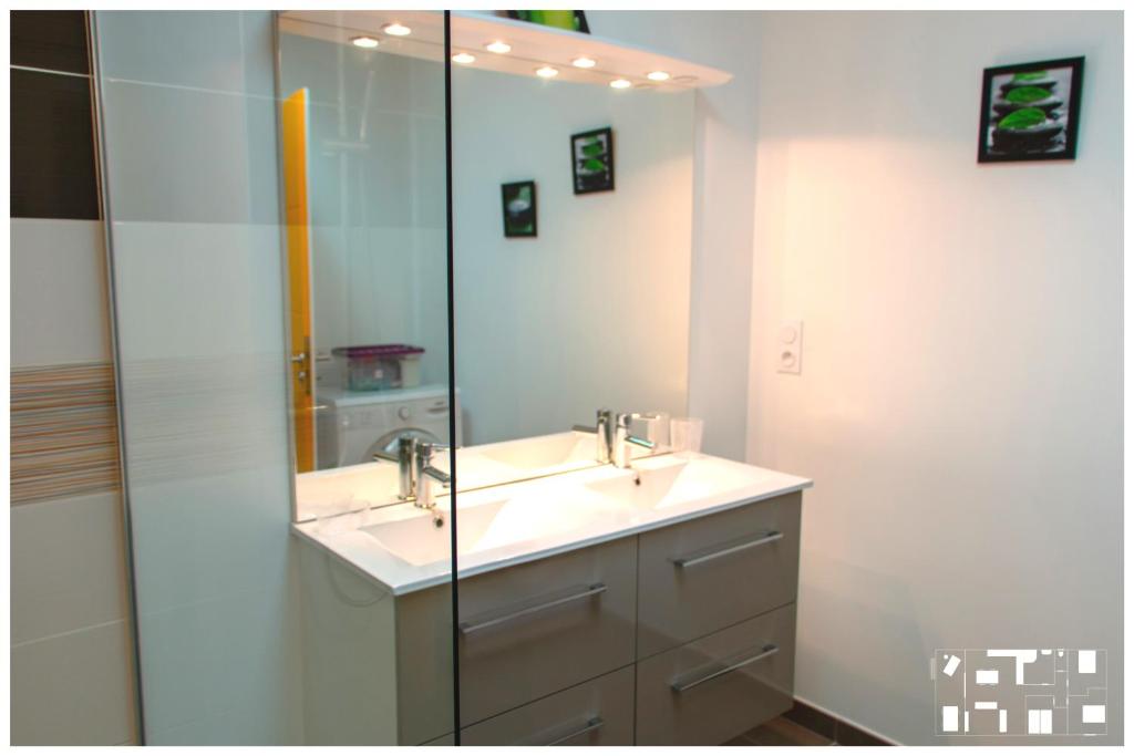 une salle de bain avec deux lavabos et un miroir dans l'établissement LE MAS AU VILLAGE, à Brouilla