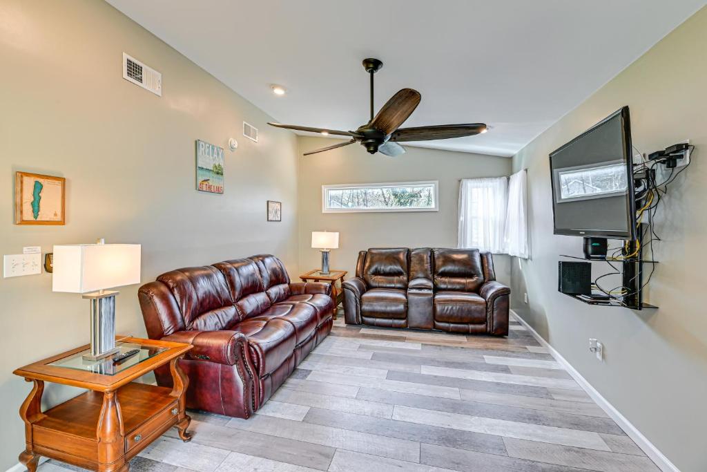 a living room with leather furniture and a flat screen tv at Pet-Friendly Honeoye Cottage Rental Walk to Lake! in Honeoye