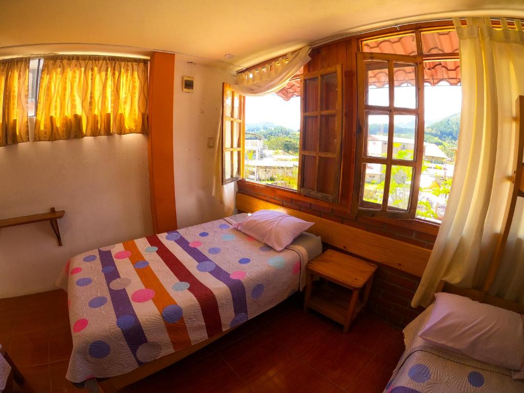 een kleine slaapkamer met een bed en een raam bij HOSPEDAJE SCHASCA in Oxapampa