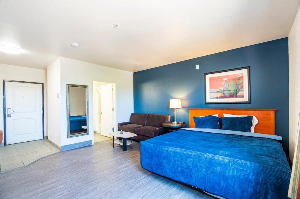- une chambre dotée d'un mur bleu avec un lit et un canapé dans l'établissement Vistas 107- Modern studio sleeps 3 with style, à Sierra Vista