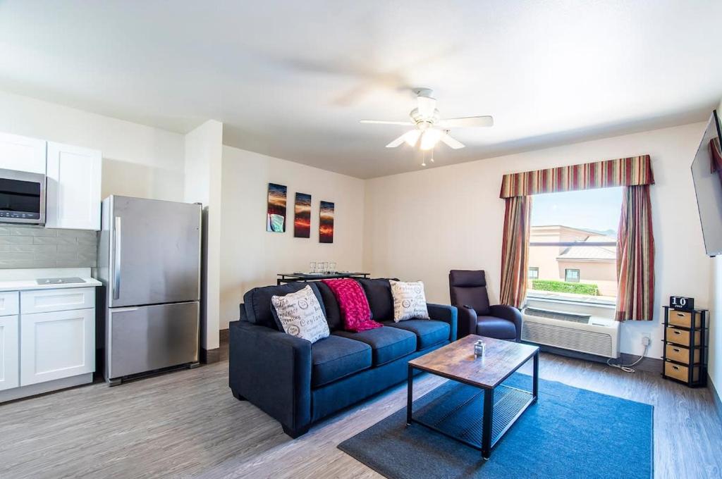 uma sala de estar com um sofá azul e um frigorífico em Vistas 202- Modern Sierra Vista 1bd great location em Sierra Vista