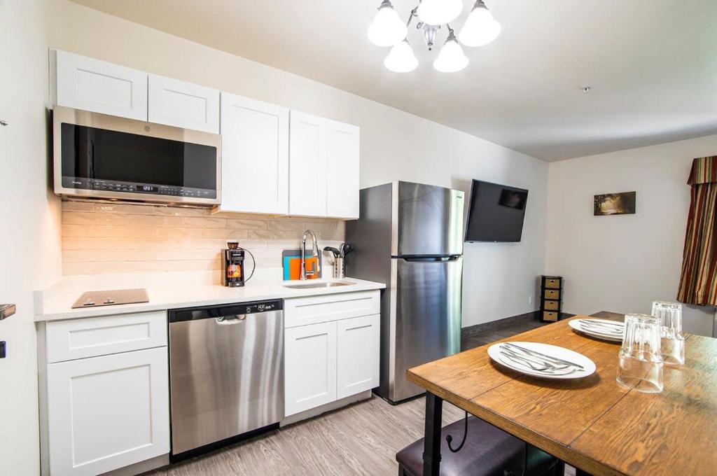 a kitchen with white cabinets and a wooden table at Vistas 216- Renovated central Sierra Vista long term discounts in Sierra Vista