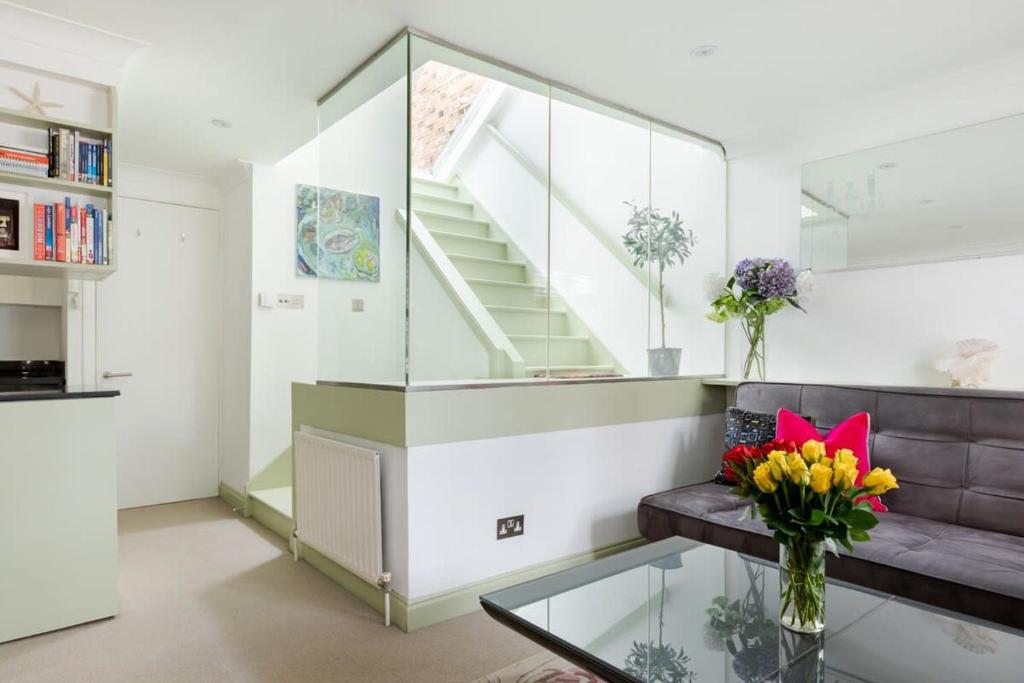 een woonkamer met een bank en een glazen tafel bij Stylish Apartment with Private Rooftop in Covent Garden in Londen