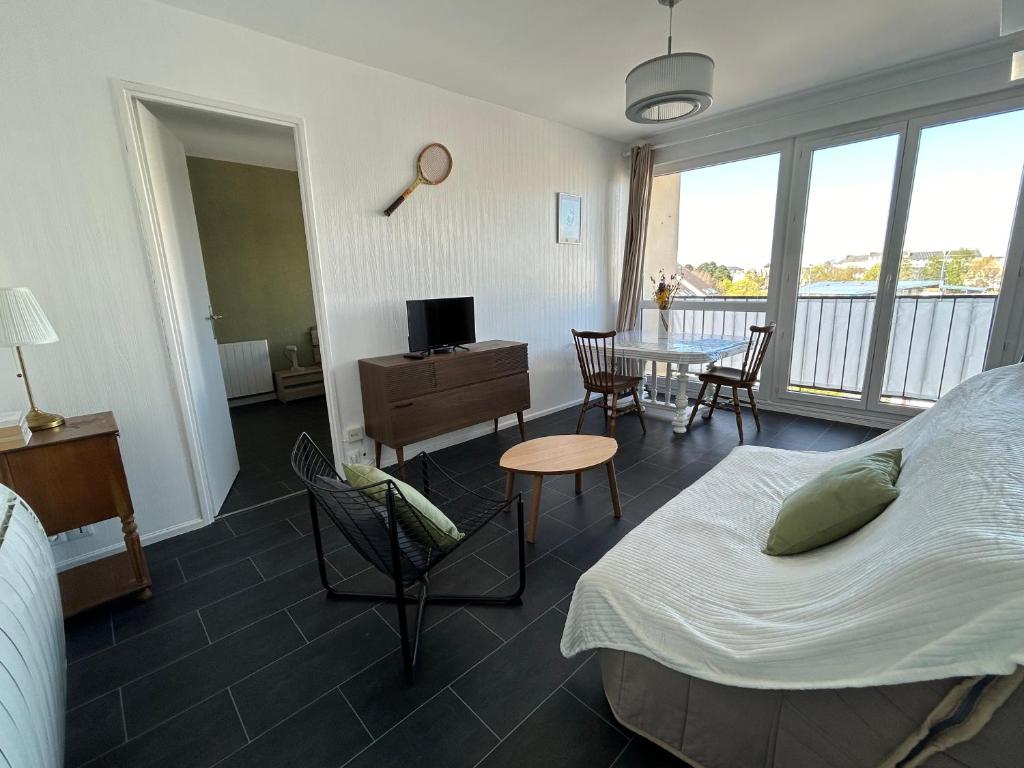 a bedroom with a bed and a table with chairs at T2 au coeur de Saint-Brieuc in Saint-Brieuc