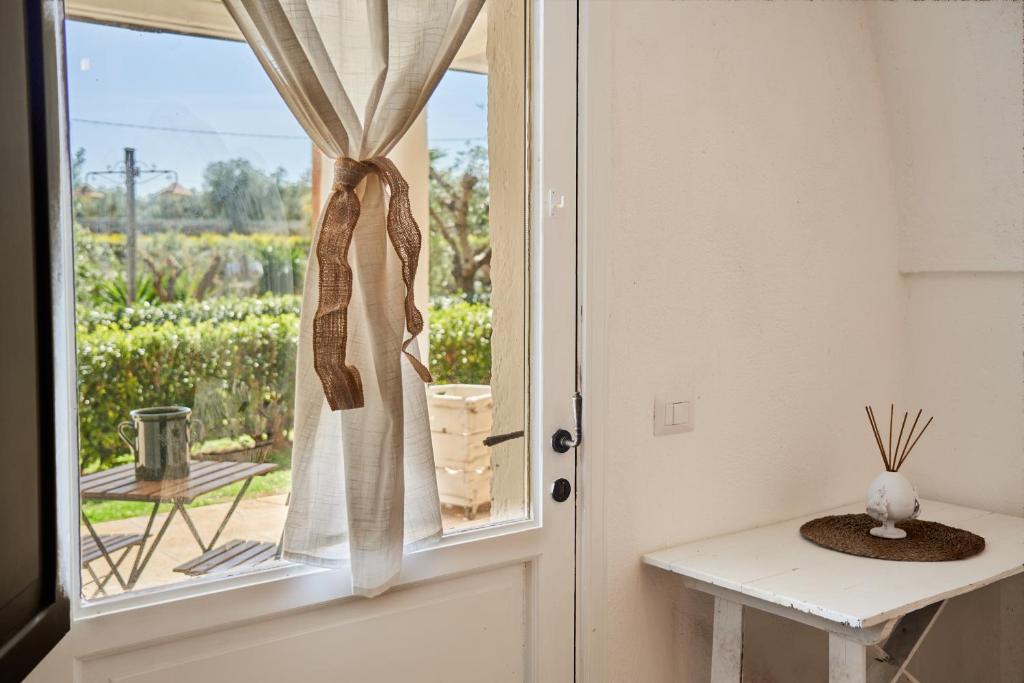 a door with a window with a view of a vineyard at Il Trappetello in Monopoli