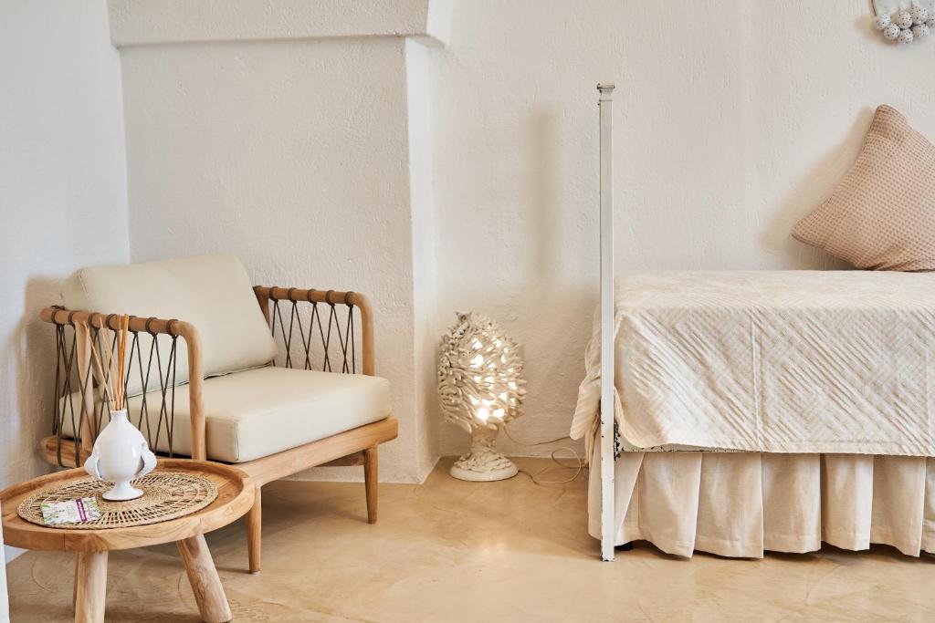 a room with a chair and a bed and a table at Il Trappetello in Monopoli